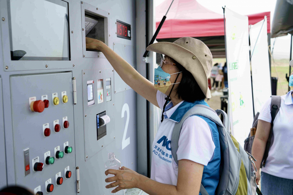 志工們將拾起的寶特瓶投入「好歸塑專車」，讓廢棄塑料空瓶可以直接粉碎、縮小體積，未來將可再製成購物袋、寶特衣、悠遊卡等生活用品